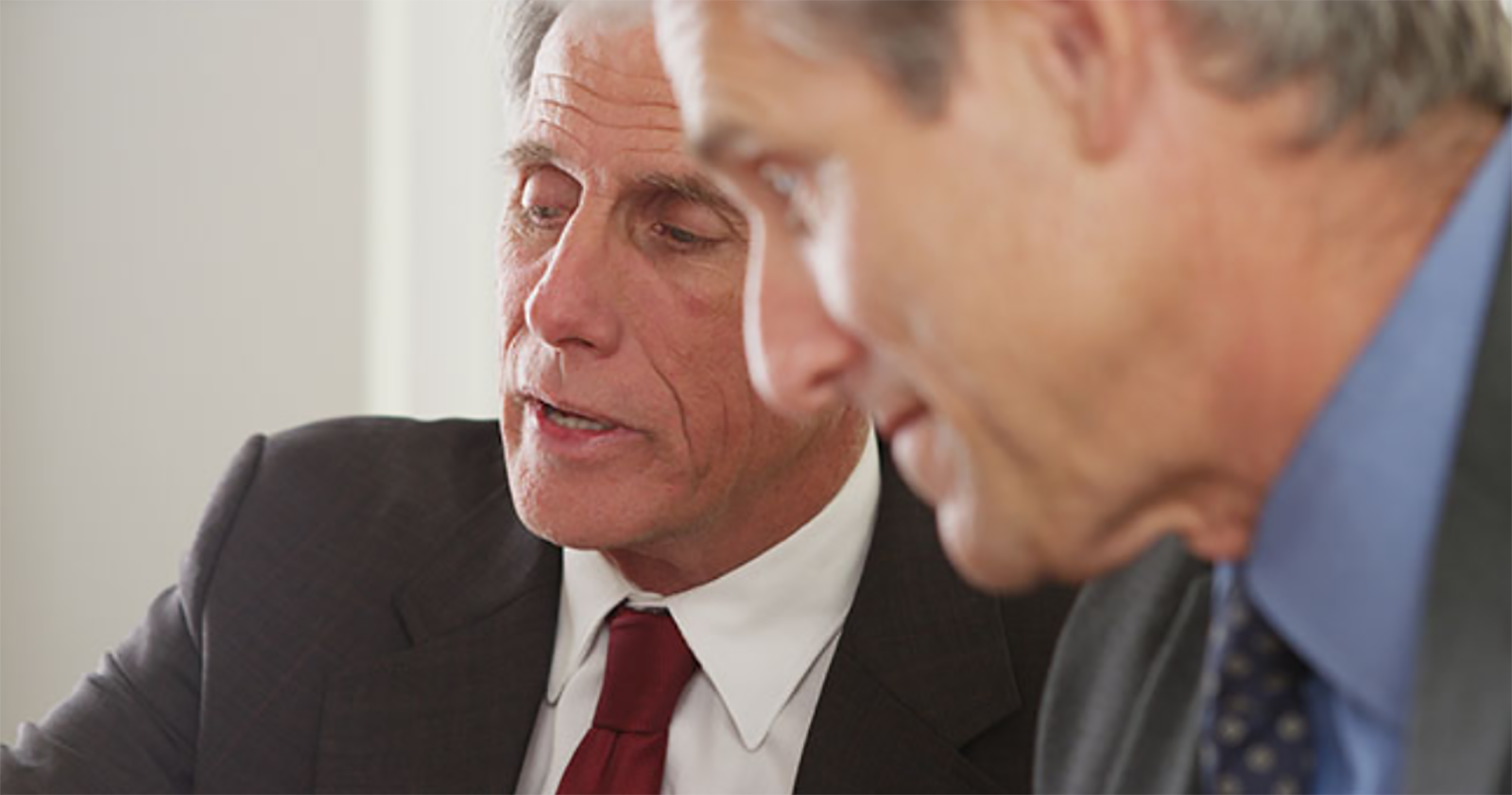 closeup of two older businessmen talking
